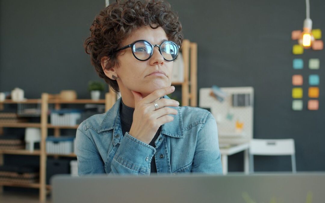 Small business owner in thought, considering the true cost of an embedded credit offer before accepting